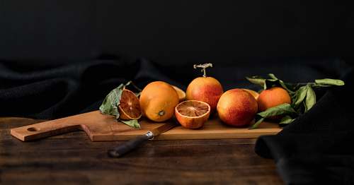 orange orange fruits on brown wooden chopping board with knife fruit