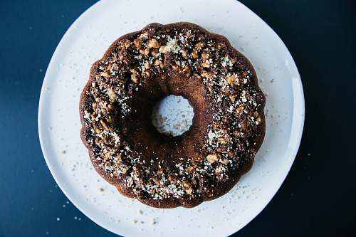 cake peanut sprinkled doughnut placed on round white ceramic saucer bundt