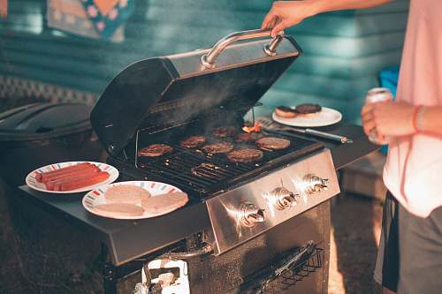 meal person cooking burger on gas grill bbq
