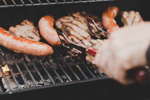 bbq person grilling sausage and meat cooking