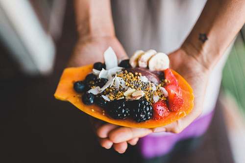 fruit person holding blue berry with strawberry dessert shallow focus photography healthy