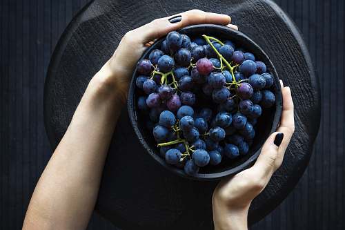 fruit person holding bowl of grapes grapes