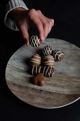 confectionery person holding chocolate ball sweets