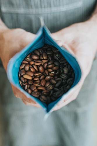 coffee person holding coffee beans in pack plant
