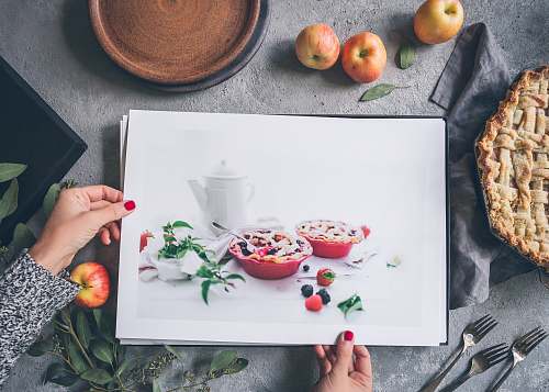 apple person holding painting beside apples flora