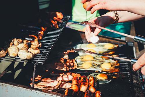 bbq person holding tong with grilled food grill