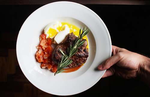 meal person holding white ceramic plate plate