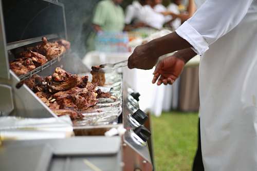 uganda person in white shirt grilling meat bbq