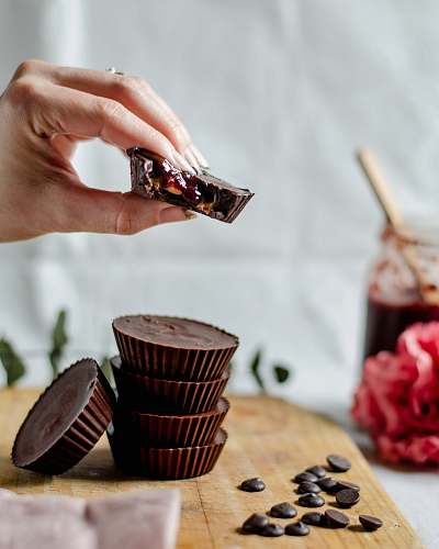 confectionery person piling cupcakes on chopping boad sweets
