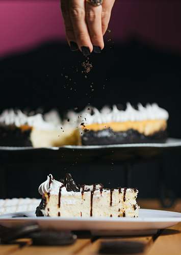 dessert person pouring chocolate powder on baked cake cake