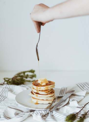 bread person pouring honey on top of pancake pancake