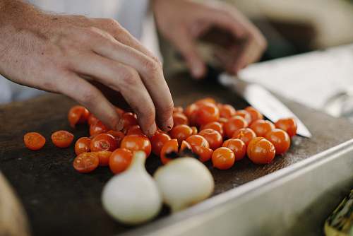 vegetable person slicing cherry tomatoes produce