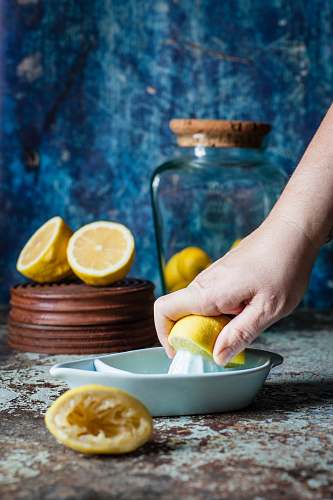 fruit person squeezing lemon on citrus press on table citrus fruit