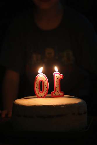 dessert person standing beside cake with 10 candles cake