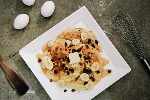plate plate of pancake topped with sliced bananas and chocolate syrup pancake