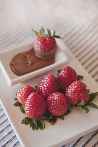 strawberry platter of strawberries with chocolate dip on on white surface fruit