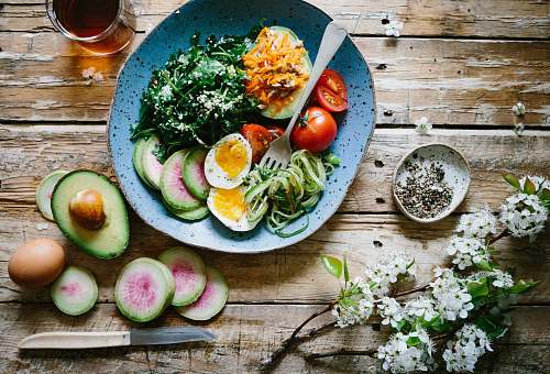 healthy poached egg with vegetables and tomatoes on blue plate meal