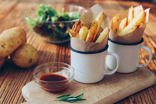 fries potato fries on mugs beside sauce cup