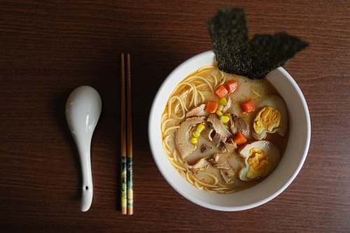 bowl ramen platter beside chopsticks and ladle dish
