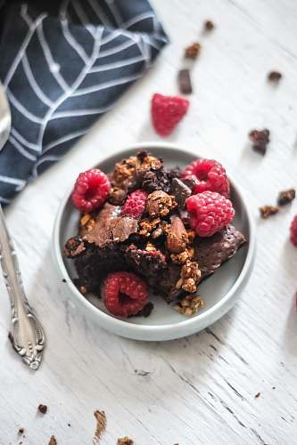 fruit raspberries and chocolate cake in plate on table plant