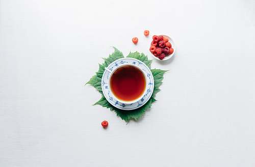 tea round white cup with saucer filled with red liquid drink