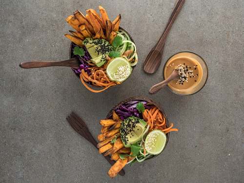 meal salad on brown wooden bowl with dip ornament