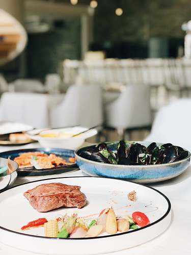 meal selective focus photography of cooked meat beside sea foods on plate restaurant