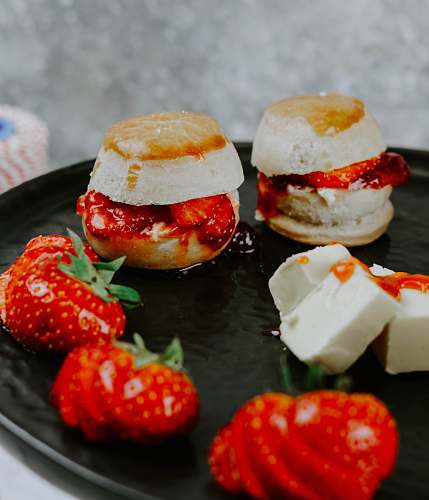 burger selective focus photography of strawberries and pastry on black plate confectionery