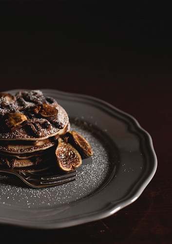 plate shallow focus photography of pan cakes with slices of banana and syrup on top on gray plate pancakes