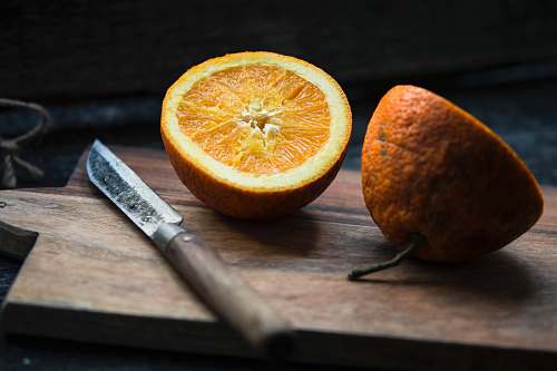 fruit shallow focus photography of sliced lemon beside knife orange