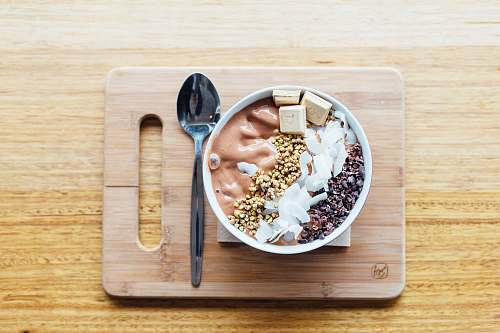 spoon silver spoon and white bowl on brown wooden chopping board breakfast