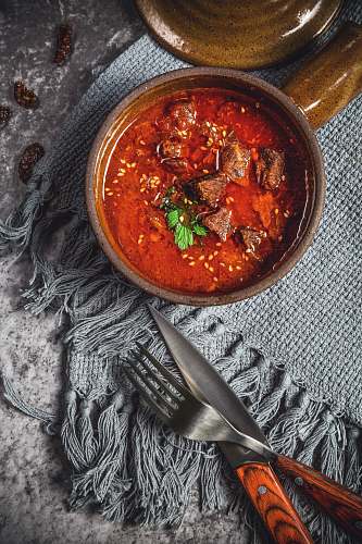 curry skewed meat in bowl beside knife and fork meat