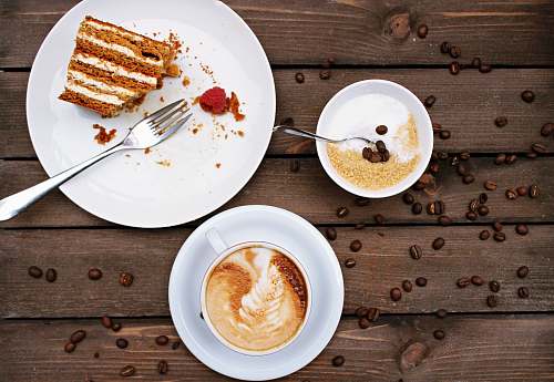 coffee slice of cake on plate beside cappuccino meal