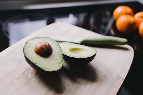 fruit sliced avocado on brown wooden chopping board avocado