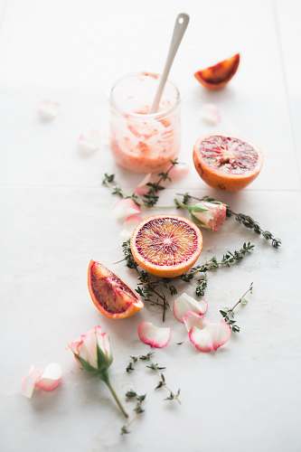 drink sliced blood orange fruits with white-and-pink petaled flowers beside fruit