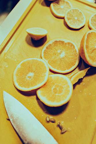 fruit sliced lemon near gray stainless steel knife citrus fruit