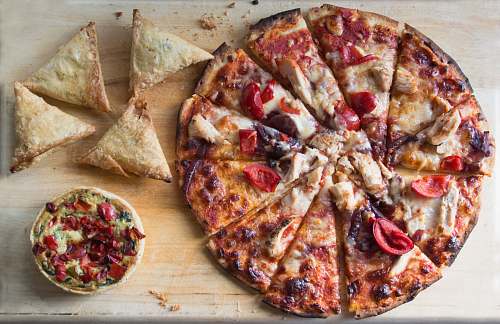 pizza sliced pizza on brown wooden table samosa