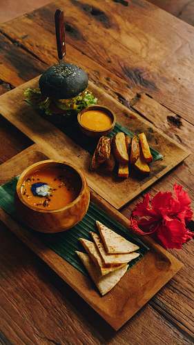 burger sliced potato beside sauce and burger on serving tray wood