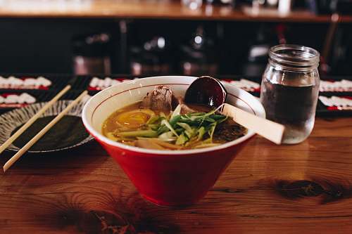 chicago soup with vegetable beside chopsticks and glass of water ramen