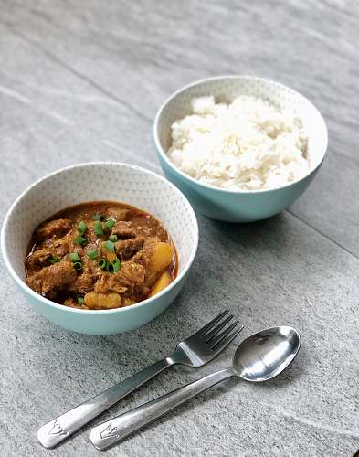 bowl spoon and fork beside two white bowls meal