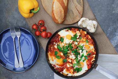 cutlery steam pasta beside tomatoes and plate fork