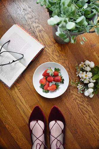 fruit strawberries on bowl beside book strawberry