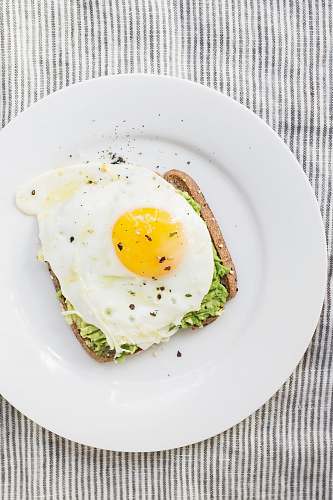 breakfast sunny side up egg, lettuce, bread on white ceramic plate healthy
