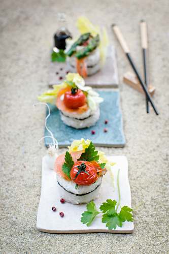 sushi sushi with toppings on white board near chopsticks dessert