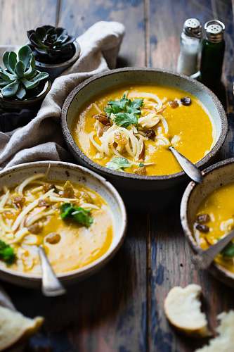 plant three noodle dishes with orange sauces in food photography soup