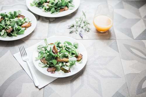 plate three salad dishes beside clear drinking glass cup salad