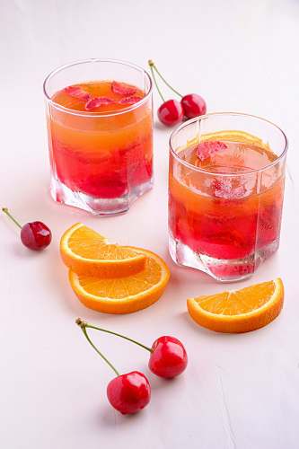 plant two orange and cherry drink in glasses orange