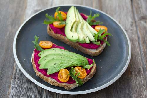 plate two sliced breads with avocado on top meal