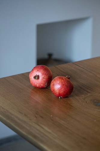 fruit two small round red fruits on brown wooden table apple