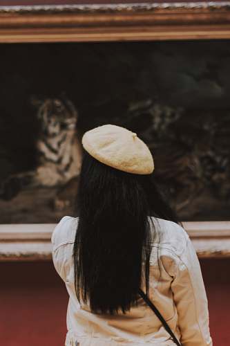 bread woman in white hat facing painting pita